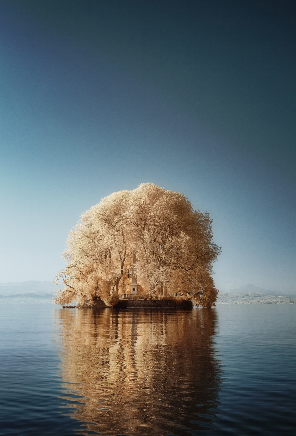 Île de la Harpe en photographie infrarouge, tons dorés et reflet sur le Léman.